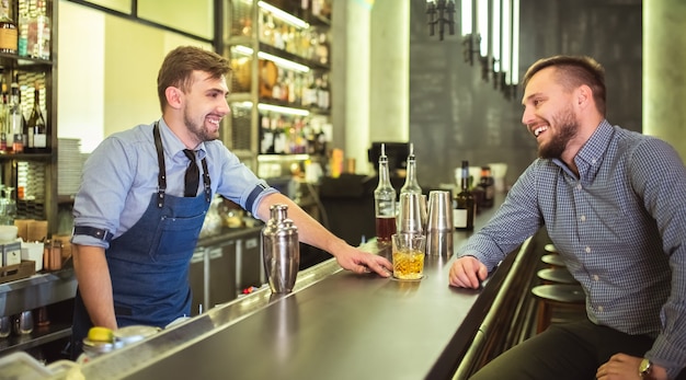 Le barman parle avec un visiteur au bar