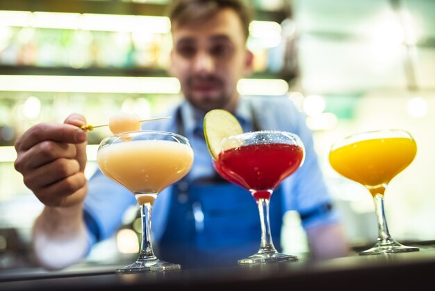 Le barman préparant des cocktails colorés au bar