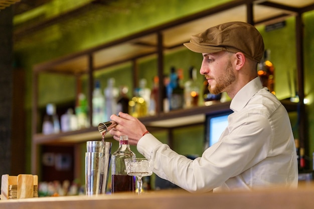 Photo le barman prépare une boisson au bar.