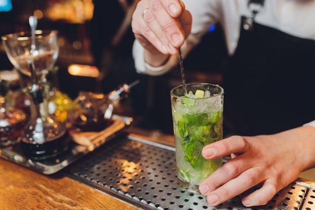 Barman prépare un cocktail au bar du restaurant.