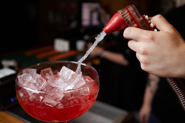 Le barman prépare un cocktail au comptoir du bar de la discothèque Close Up Concept sur le service et les boissons