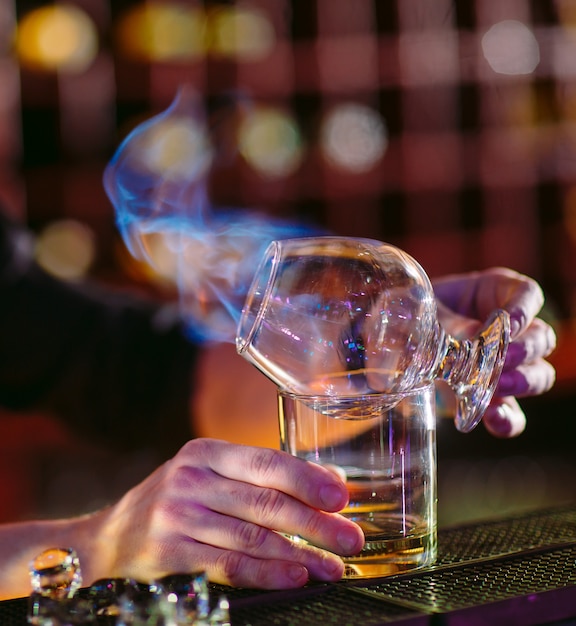 Le barman prépare un cocktail chaud.