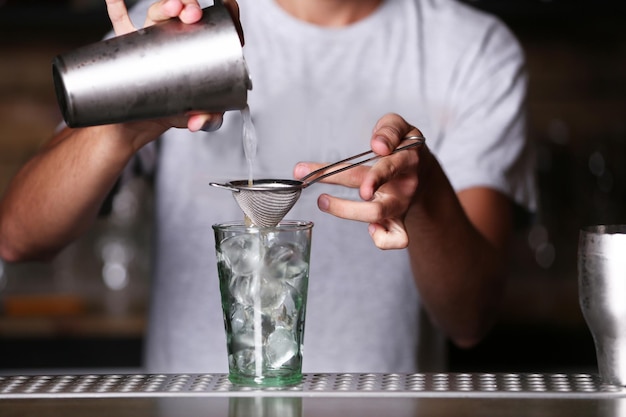 Photo le barman prépare un cocktail sur le comptoir du bar