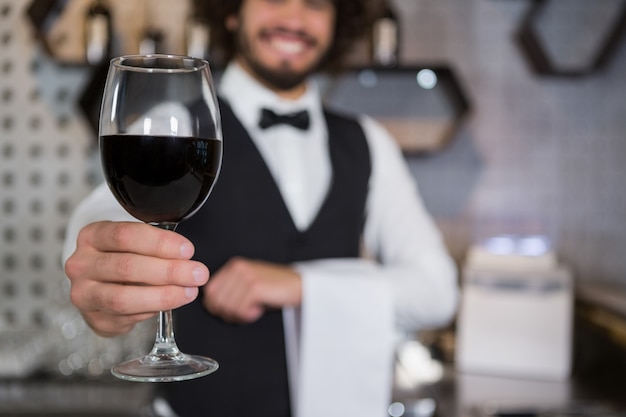 Barman servant un verre de vin rouge dans le comptoir du bar