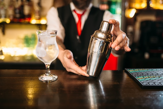 Barman avec shaker derrière un comptoir de bar