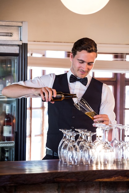 Photo barman souriant versant une bière dans un verre