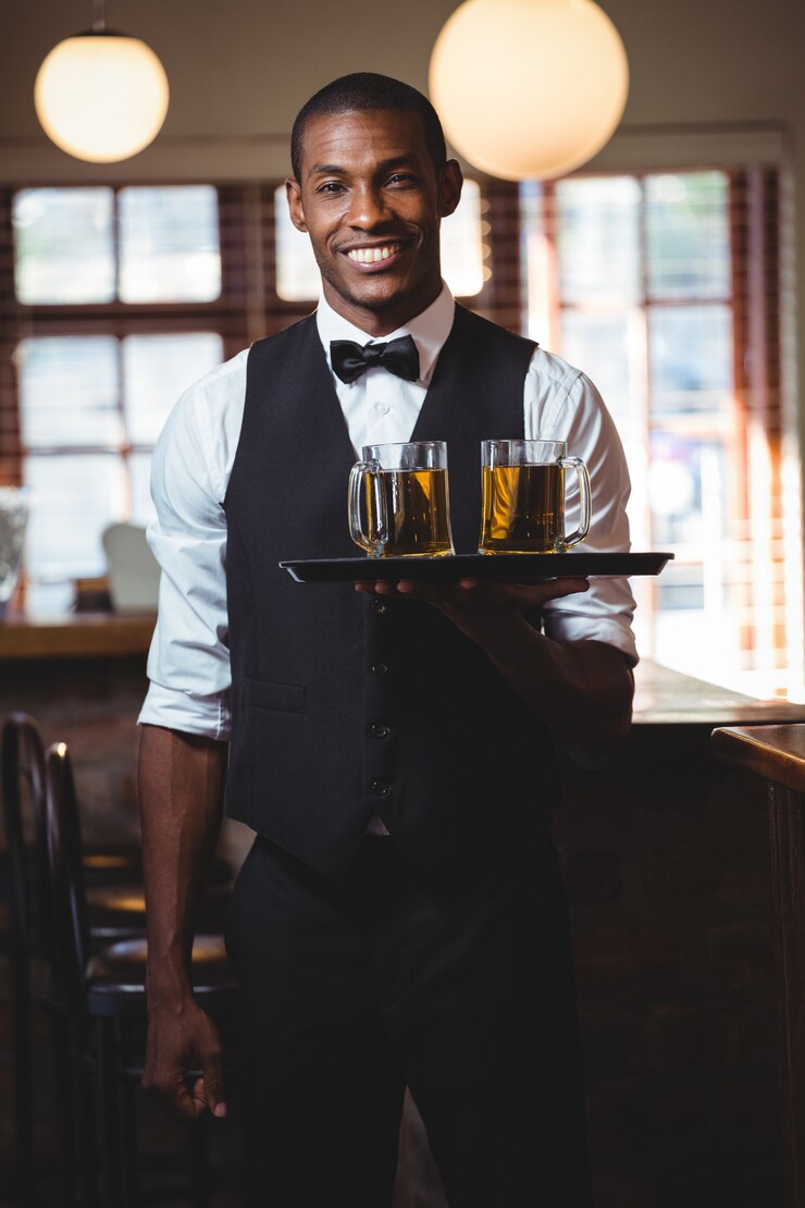 Barman tenant un plateau de service avec des verres de bière