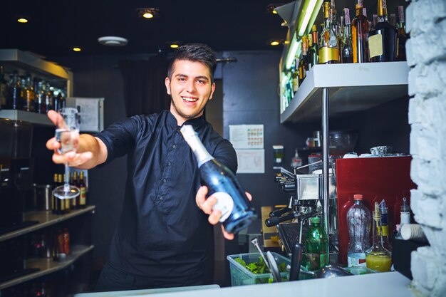 Barman avec verre de champagne vide au bar