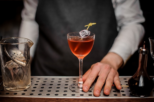 Barman avec un verre à cocktail rempli de boisson d'été