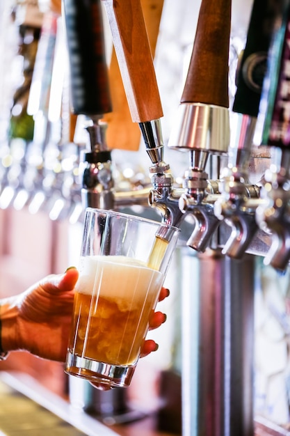 Barman versant de la bière pression au bar.