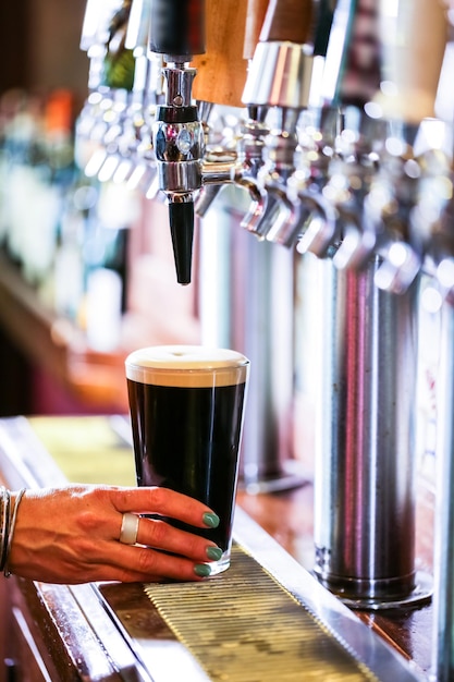 Barman versant de la bière pression au bar.