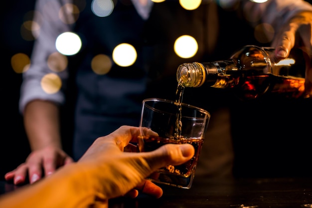 Barman versant du whisky verre à whisky belle nuit