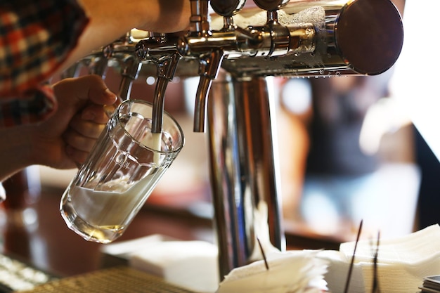 Photo le barman verse de la bière dans le verre