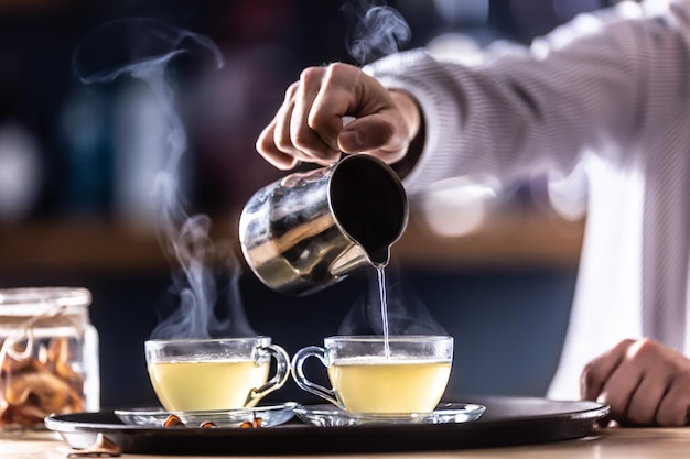 Le barman verse du vin chaud chaud ou une boisson au whisky d'hiver Hot Toddy