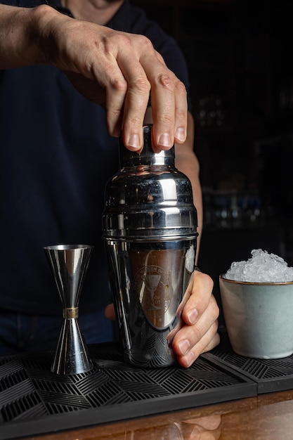 Un barman verse un shaker dans un shaker.