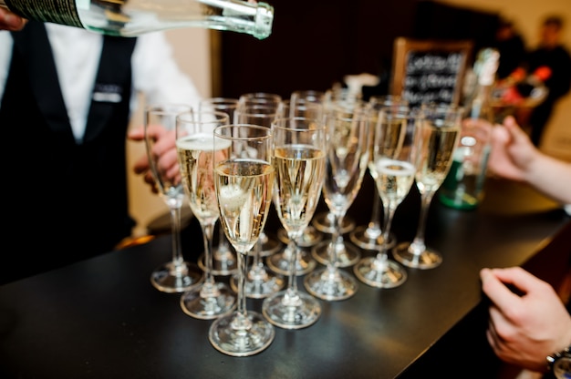 Barman verser du champagne dans un verre sur le bar