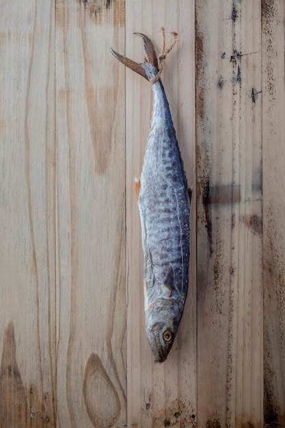 Photo barracuda salé suspendu sur un fond en bois ancien.