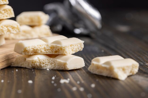 Une barre de chocolat blanc cassée en morceaux