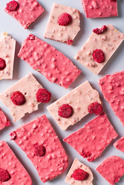 Barre de chocolat rubis ou rose à plat sur fond bleu copie espace vue de dessus