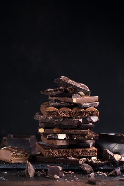 Barre de morceaux de tour de chocolat noisettes et amandes morceaux de chocolat noir cassé concept de photo d'aliments sucrés