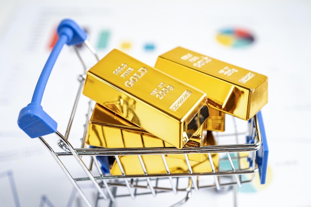 Barre d'or dans le panier sur les billets en dollars américains argent et graphique économie finance échange commerce concept d'investissement