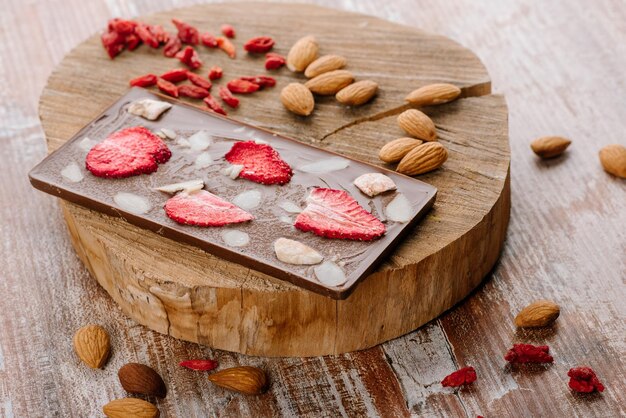 Barre sucrée de chocolat aux fruits et noix sur le fond en bois