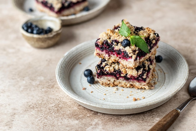 Barres d'avoine aux bleuets sur une assiette à la menthe sur beige Espace de texte de composition de petit-déjeuner sain