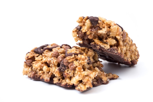 Barres de céréales au chocolat avec grains entiers de blé et de chocolat sur un fond blanc.