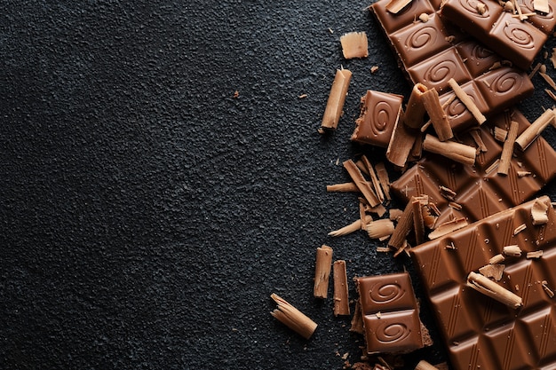 Barres de chocolat cassées sur une surface sombre