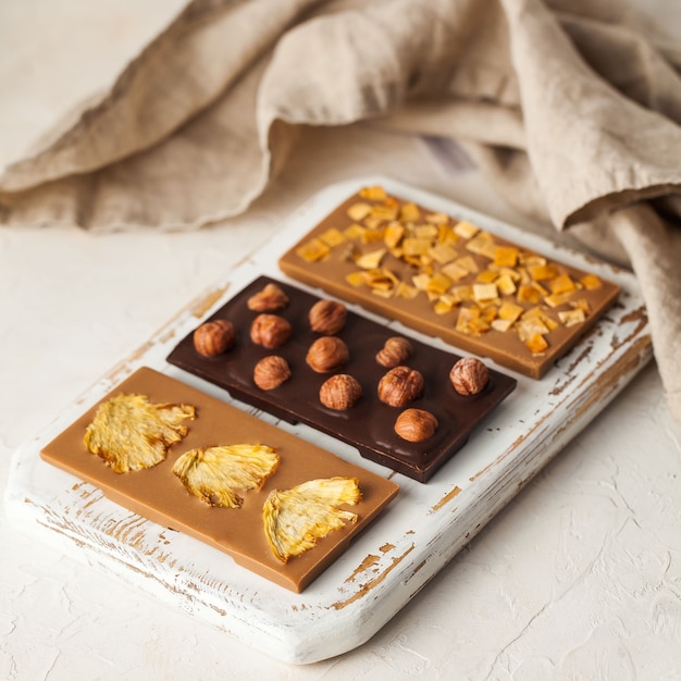 Barres de chocolat végétaliennes assorties trois sortes de chocolat aux noisettes entières ananas mangue tranches o ...