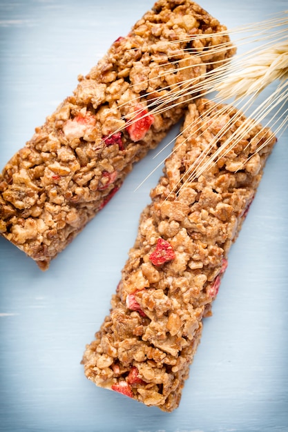 Barres de muesli, barres de céréales sur le fond en bois.