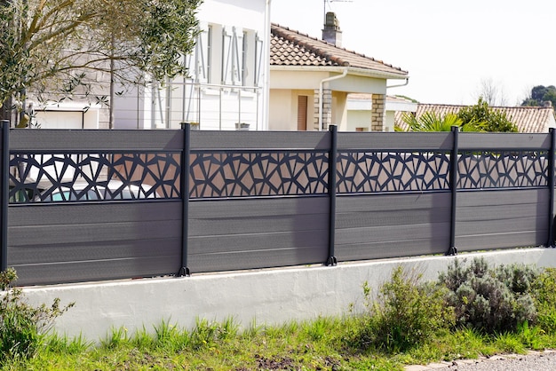 Barrière moderne grise de mur de la protection de conception de maison de banlieue vue sur le jardin de la maison