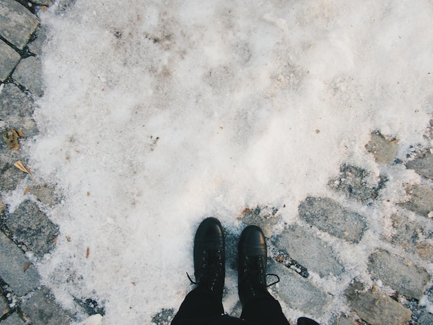 Photo bas de la personne debout par la neige sur le sentier pendant l'hiver