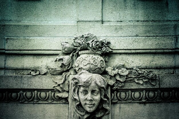 Bas-relief en pierre texturé antique du visage d'une fille