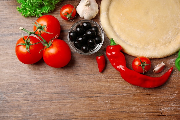 Base de pâte et ingrédients pour pizza, sur la table