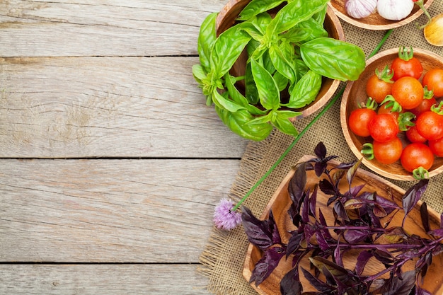 Basilic et tomates frais d'agriculteurs sur la table en bois avec l'espace de copie