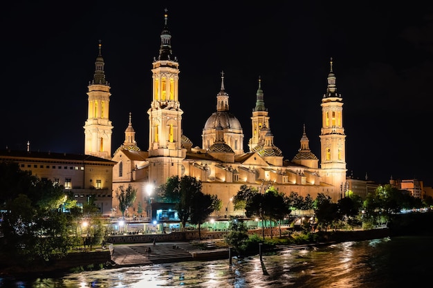 Basilique cathédrale du Pilar de Saragosse illuminée la nuit à côté de la rivière Ebro Espagne