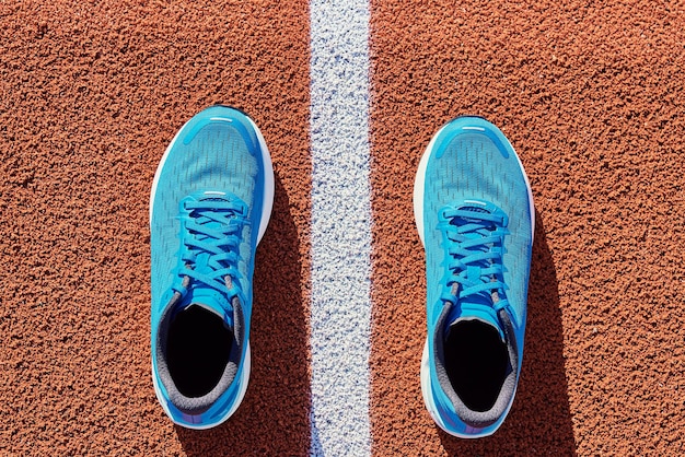 Baskets de course bleues sur la piste du stade