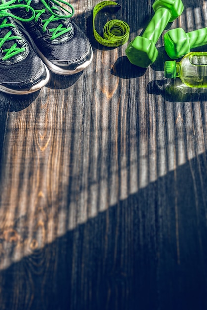 Photo des baskets, des haltères et une bouteille d'eau. vue plate. le tout en une seule couleur.