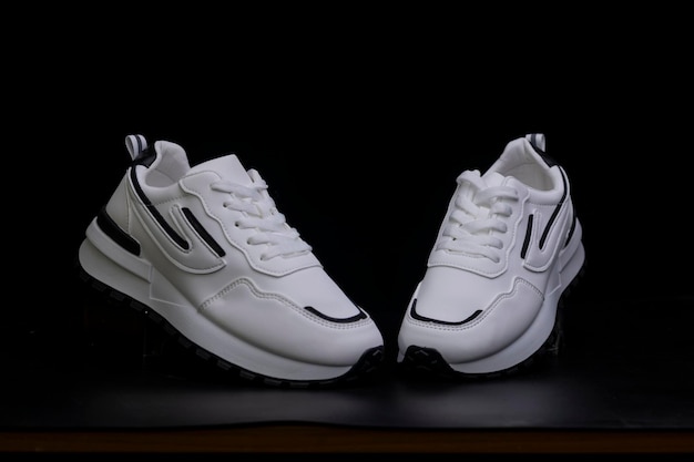 Photo des baskets de sport blanches sur fond noir