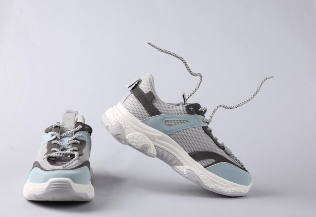 Baskets de sport avec lacets volants sur fond gris