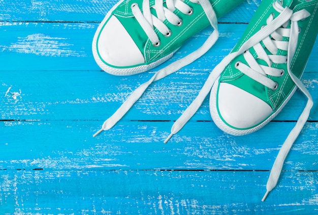 Baskets en textile vert sur un bois bleu