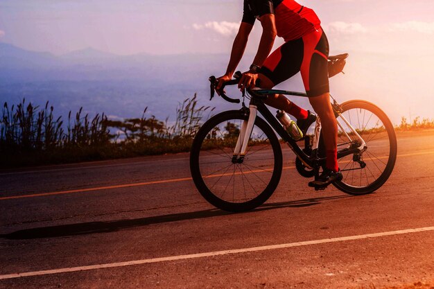 Photo basse section de l'homme à vélo sur la route contre le ciel