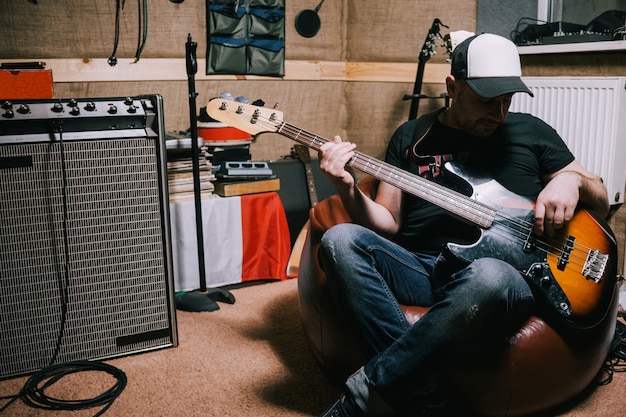 Bassiste jouant de la guitare en studio de musique