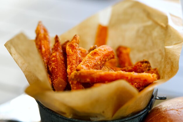 Batata frite dans un bol sur fond de bois