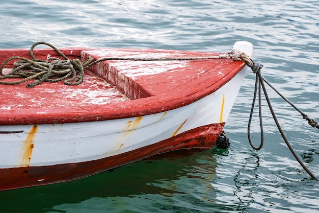 Bateau amarré rouge et blanc en métal et bois