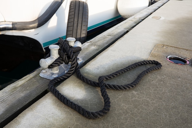 Bateau blanc attaché à la jetée avec une corde noire