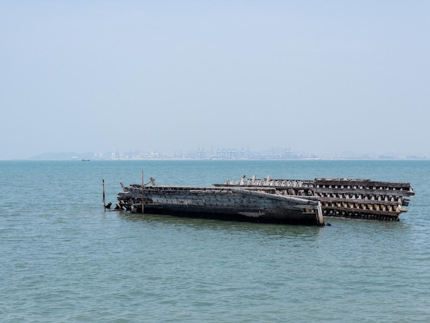 Un bateau en bois abandonné s'est échoué sur le rivage près du port