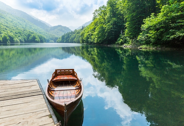 Bateau en bois au quai sur le lac de montagne