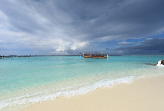 un bateau en bois flotte sur une île tropicale